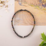Tourmaline bracelet resting on soft flower petals, evoking calm and protection
