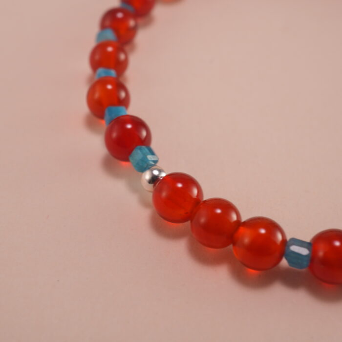 Close-up of 4mm red agate and blue apatite beads on energy bracelet