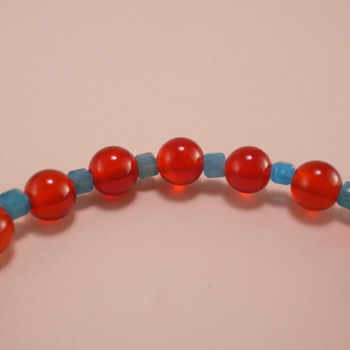 Close-up of 4mm red agate and blue apatite beads on energy bracelet