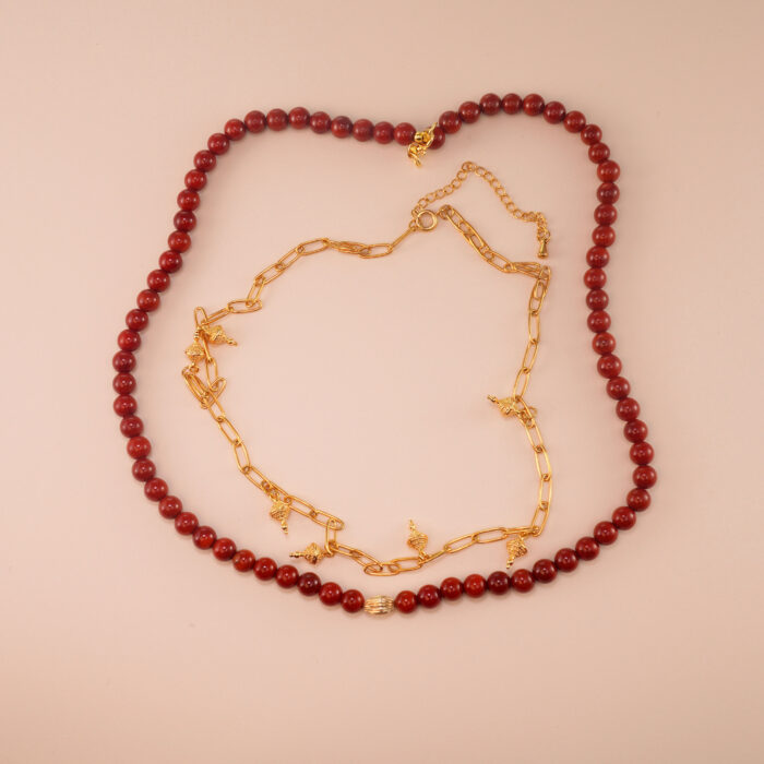 Handmade red agate round bead necklace neatly laid on a light background