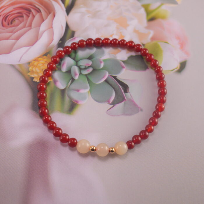 Red agate and chalcedony bracelet styled near flowers and crystals – calming energy scene