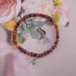 Agate charm bracelet styled with natural props for vitality and grounding