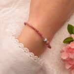 Adjustable healing bracelet worn on the wrist with stacked jewelry