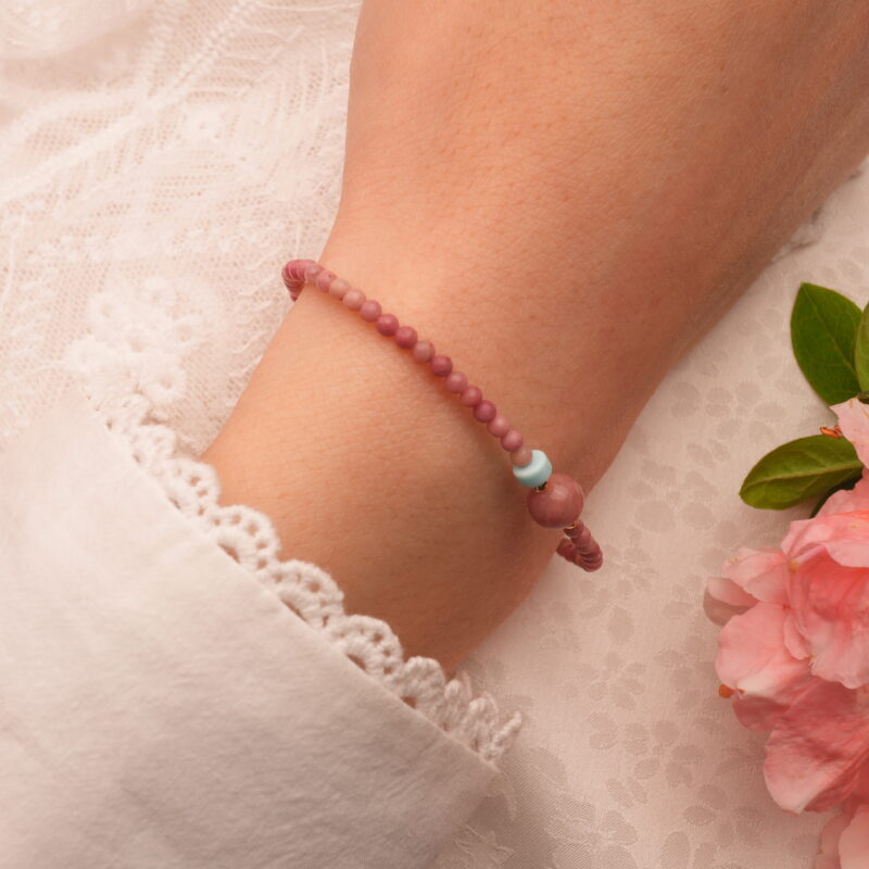 Adjustable healing bracelet worn on the wrist with stacked jewelry
