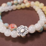 Close-up of gemstone textures and floral charm on chalcedony bracelet