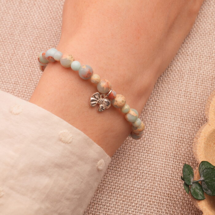 Wrist shot showing the Shoushan stone bracelet worn with a neutral-toned outfit