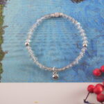 Chalcedony flower charm bracelet placed on a silk pillow, suggesting peaceful rest