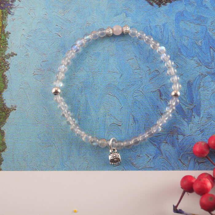 Chalcedony flower charm bracelet placed on a silk pillow, suggesting peaceful rest