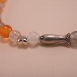 Close-up of natural chalcedony and moonstone beads with detailed S925 fish charm