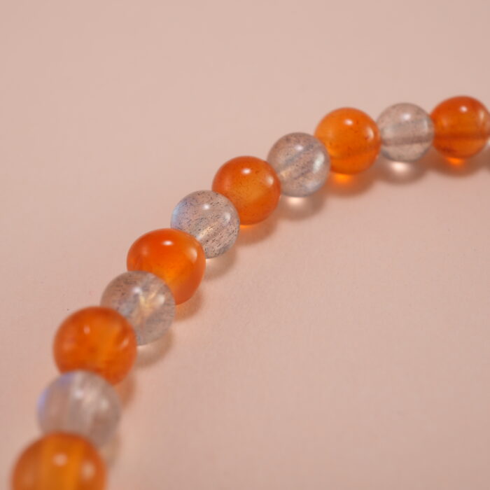 Close-up of natural chalcedony and moonstone beads with detailed S925 fish charm