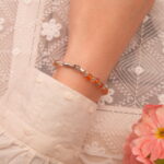 Model wearing 4mm sleep crystal bracelet with orange chalcedony and gray moonstone beads