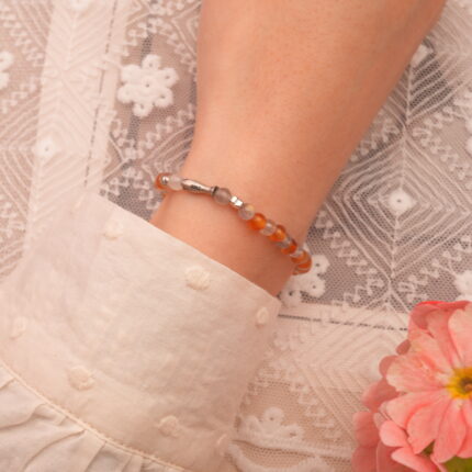Model wearing 4mm sleep crystal bracelet with orange chalcedony and gray moonstone beads
