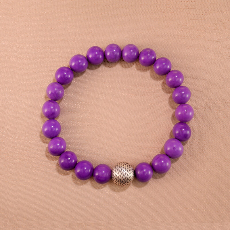 Phosphosiderite bracelet made of round purple 8mm beads, neatly arranged on a light background