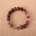 A Purple Phantom Quartz bracelet with translucent 8mm beads, laid flat on a clean white surface