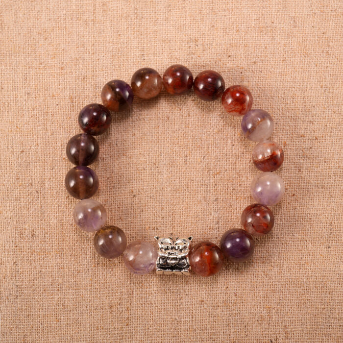 A Purple Phantom Quartz bracelet with translucent 8mm beads, laid flat on a clean white surface