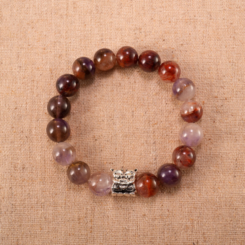 A Purple Phantom Quartz bracelet with translucent 8mm beads, laid flat on a clean white surface