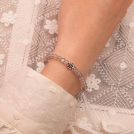 A wrist gently adorned with the moonstone bracelet, highlighting its light-reflective quality
