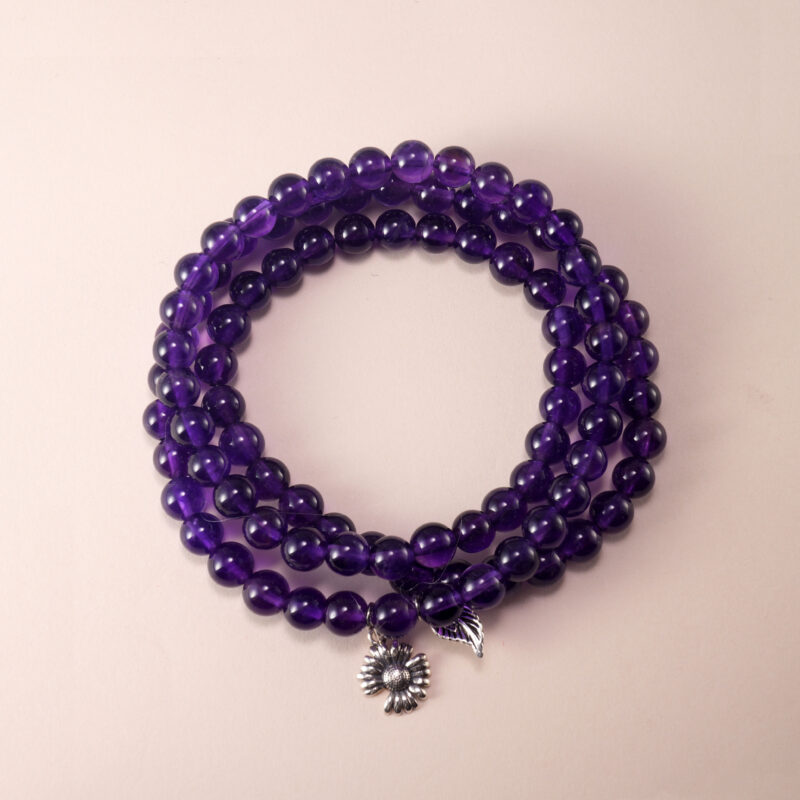 Triple-layer 6mm Uruguay Amethyst bracelet neatly displayed on a neutral background