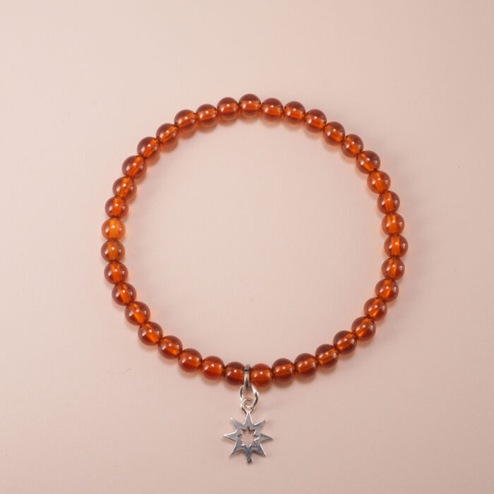 Garnet bracelet with silver star charm on a clean white background