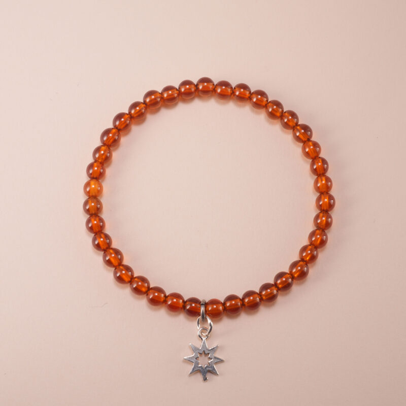 Garnet bracelet with silver star charm on a clean white background