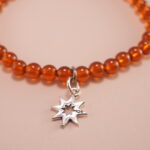Close-up view of garnet beads and sterling silver star charm
