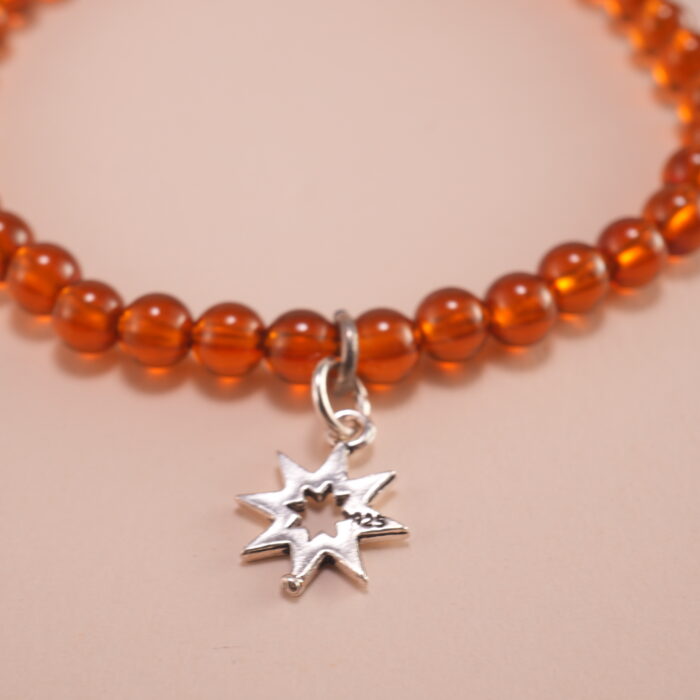 Close-up view of garnet beads and sterling silver star charm
