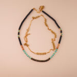 Tibetan turquoise and black tourmaline necklace laid flat on neutral or spiritual background