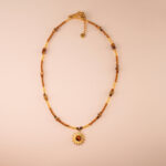 Handmade tiger eye bead necklace with sunflower pendant on white background