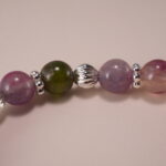 Close-up of Multicolor Tourmaline Beads and Silver Cross Charm