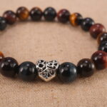 Close-up of heart charm and polished Tiger Eye beads