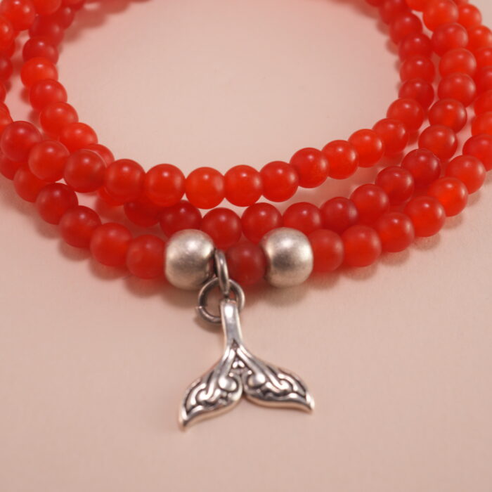 Close-up of red agate beads and silver charm details