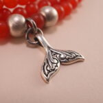 Close-up of red agate beads and silver charm details