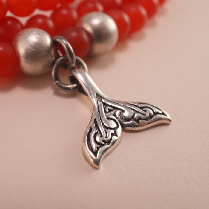 Close-up of red agate beads and silver charm details