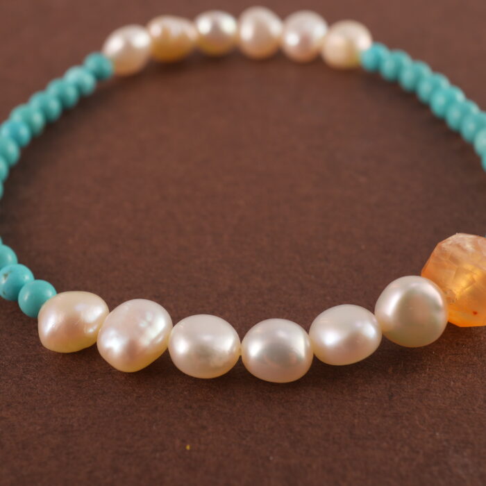Close-up of turquoise and pearl beads on bracelet