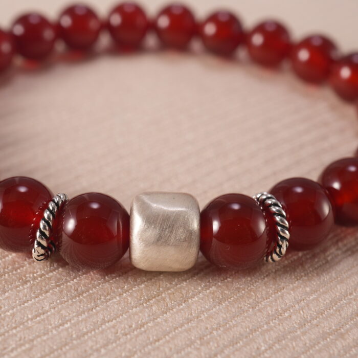Close-up of red agate beads and silver detailing on 8mm bracelet