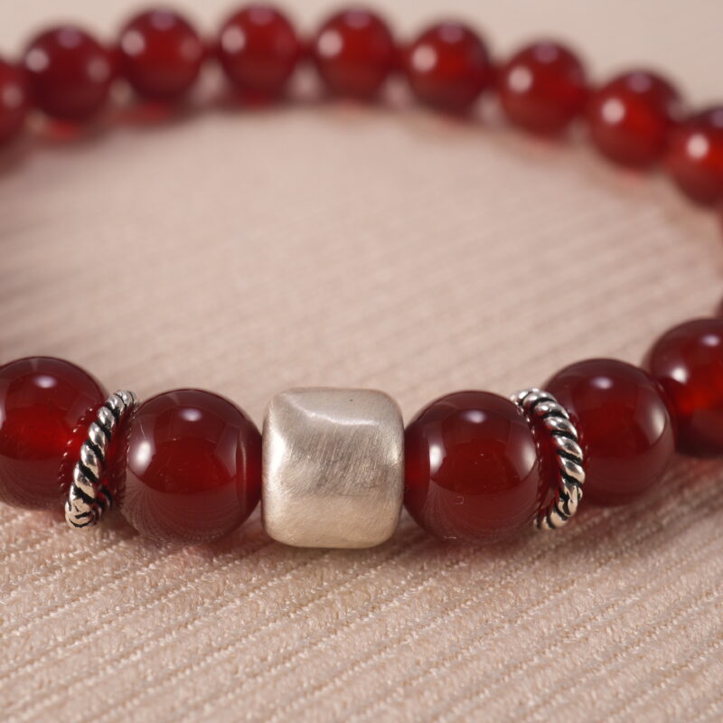 Close-up of red agate beads and silver detailing on 8mm bracelet