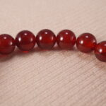 Close-up of red agate beads and silver detailing on 8mm bracelet