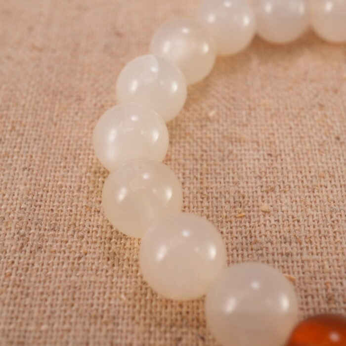 Close-up of the heart-shaped agate bead and surrounding polished stones