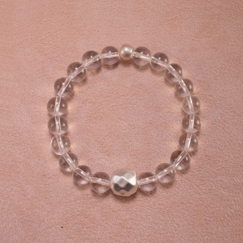 Clear quartz 8mm bracelet with silver accents on white background
