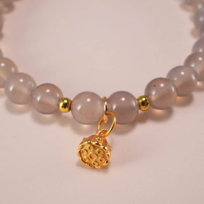 Close-up of polished agate beads and silver charm