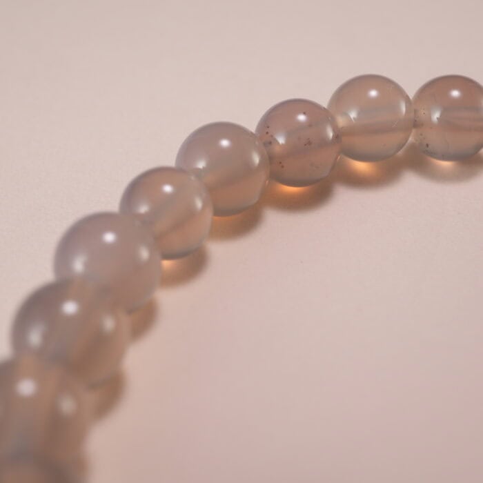 Close-up of polished agate beads and silver charm