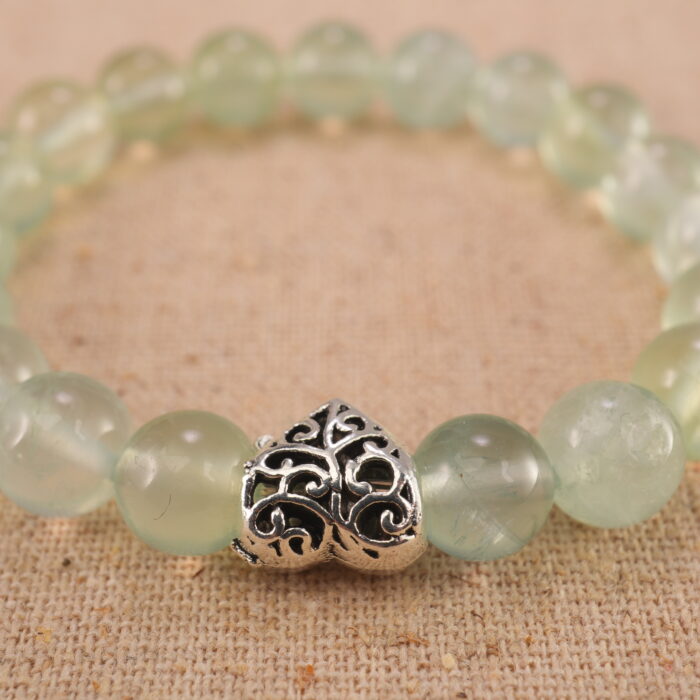 Close-up of heart-shaped Prehnite beads with soft green tones