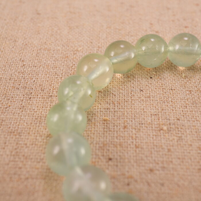 Close-up of heart-shaped Prehnite beads with soft green tones