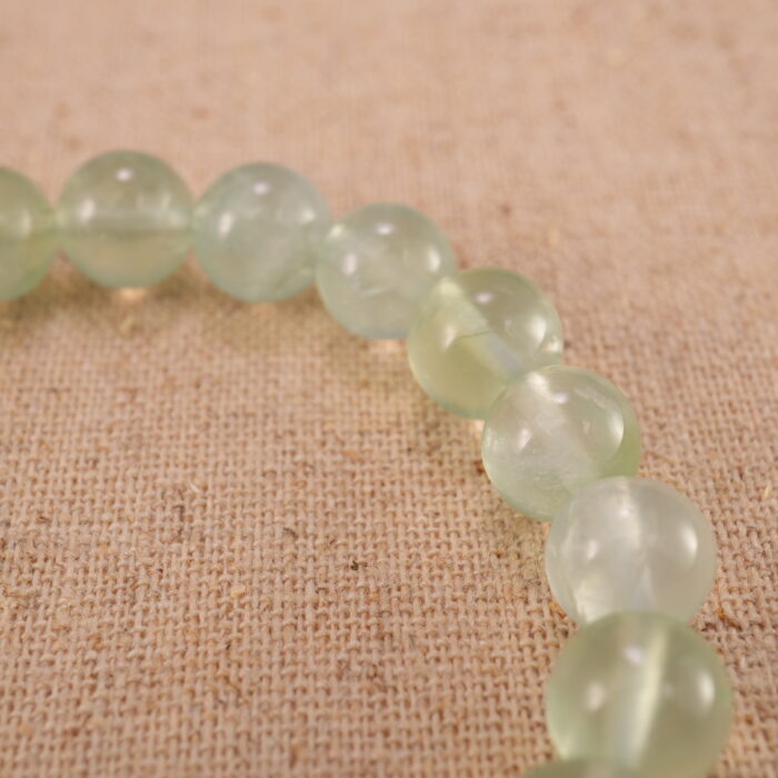 Close-up of heart-shaped Prehnite beads with soft green tones