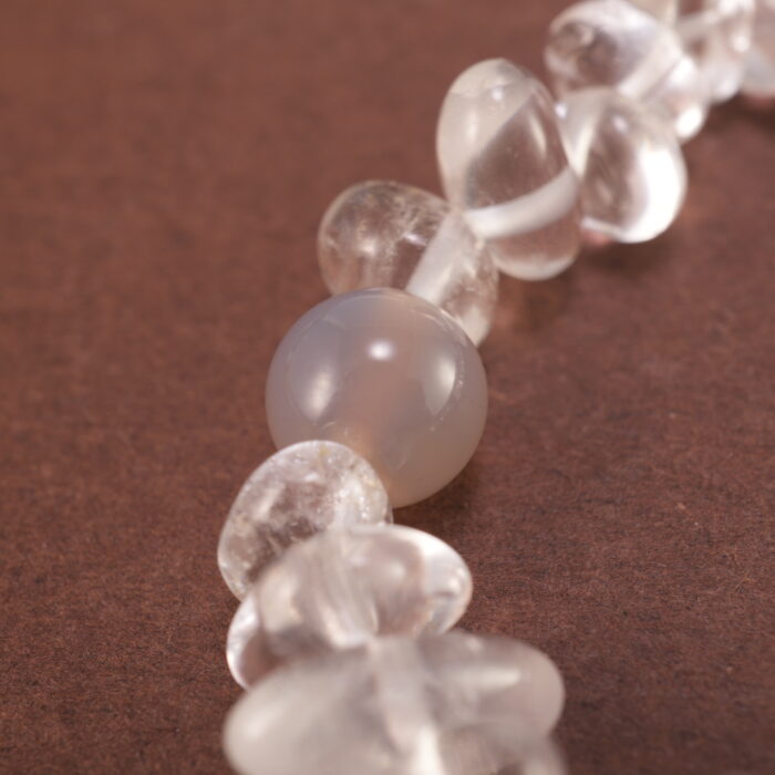 Close-up of rough-cut Clear Quartz with polished Gray Agate beads