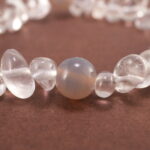 Close-up of rough-cut Clear Quartz with polished Gray Agate beads