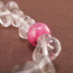 Close-up of rough-cut Clear Quartz with polished Gray Agate beads