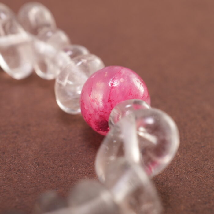 Close-up of rough-cut Clear Quartz with polished Gray Agate beads