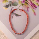 Dainty red agate bracelet styled with natural textures for a clean, serene mood