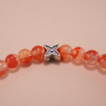 Close-up of carnelian beads and silver detailing on 4mm bracelet